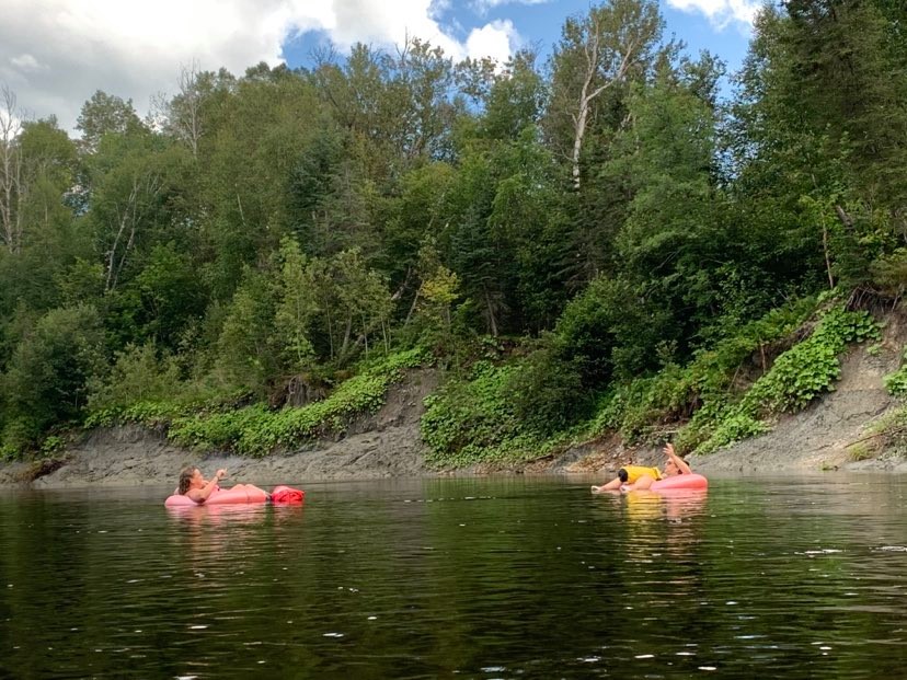 Deux filles sur leurs tripes roses se laissent porter par le courant de la rivière du Gouffre.